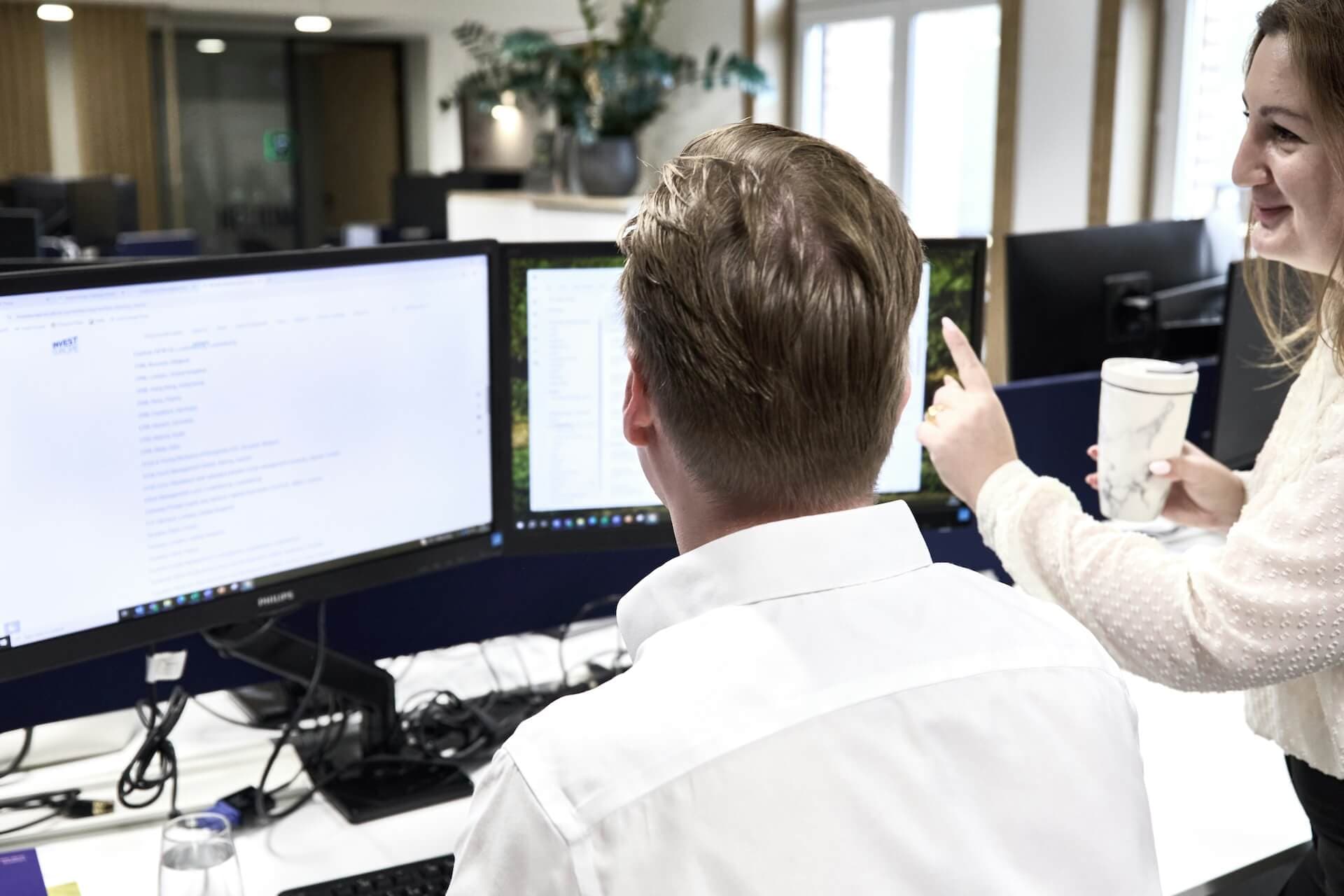 Financial analyst reviewing charts and financial data on multiple screens